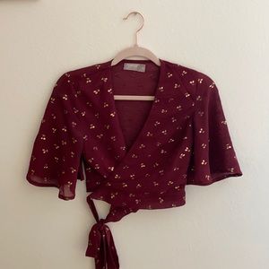 Red flutter sleeve wrap top with gold cherry print